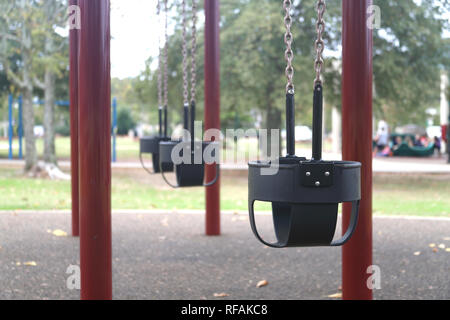 Swing set in children's playground park used for recreational activity and exercise Stock Photo
