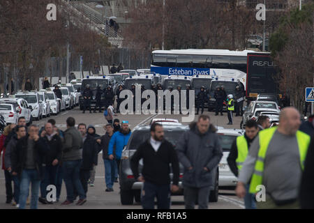 Madrid, Spain. 24th January, 2019. Police standing guard during a taxi driver  strike near Fitur, the Tourism Fair that is to take place this week at IFEMA in Madrid. The drivers are demanding more stringent regulation for rental vehicles with drivers (VTC), who use Uber or Cabify applications. Credit: SOPA Images Limited/Alamy Live News Stock Photo