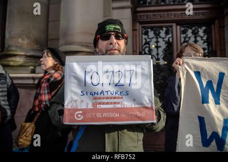 Glasgow, Renfrewshire, UK. 24th Jan, 2019. A man is seen holding the box of signatures during the rally.The organization called Get Glasgow Moving held a protest outside of the City Chambers in Glasgow before handing over a box containing 10,727 signatures to members of the Council, saying that the transport should not be in the hands of private companies but in the publics. Credit: Stewart Kirby/SOPA Images/ZUMA Wire/Alamy Live News Stock Photo