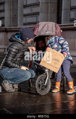 Glasgow, Renfrewshire, UK. 24th Jan, 2019. Kids seen with their mother holding a placard at the rally.The organization called Get Glasgow Moving held a protest outside of the City Chambers in Glasgow before handing over a box containing 10,727 signatures to members of the Council, saying that the transport should not be in the hands of private companies but in the publics. Credit: Stewart Kirby/SOPA Images/ZUMA Wire/Alamy Live News Stock Photo