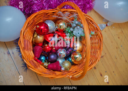 Easter basket filled with hand painted . The wattled basket . A Christmas red and gold ball . Golden and red christmas baubles . Christmas gifts in th Stock Photo