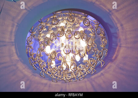 Modern layered ceiling with embedded lights and stretched ceiling inlay, light turned on - Image Stock Photo