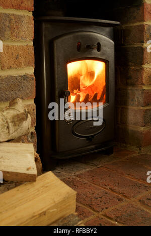 Woodburning stove burning logs in a brick fireplace. Stock Photo