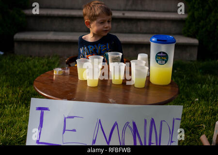 A 5-year old boy sits at a lemonade stand with cups and a pitcher of  lemonade Stock Photo - Alamy