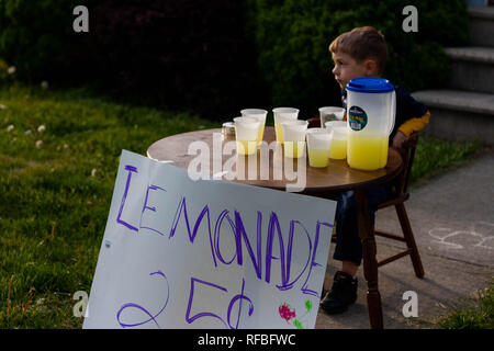 A 5-year old boy sits at a lemonade stand with cups and a pitcher of  lemonade Stock Photo - Alamy