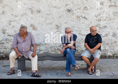 Ravello, Salerno / Italy - August 14 2018 : Three men sat on a bench in Ravello, Italy. Stock Photo