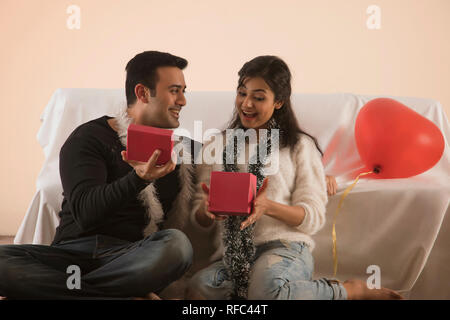 young woman receiving a gift from her boyfriend and surprised Stock Photo