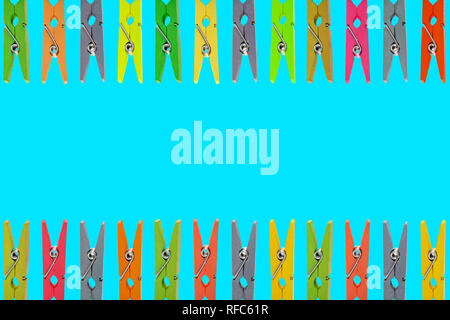 Colorful wooden clothespins on Blue background Stock Photo