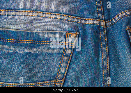 Blank real leather jeans label sewed on old worn blue jeans. Denim background, jeans, closeup surface of denim. Stock Photo