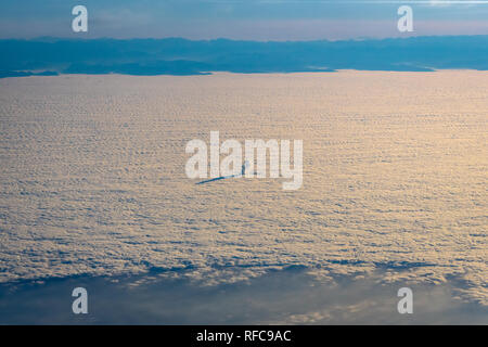 Smoke and steam from power plant rising through cloud cover in Germany Stock Photo