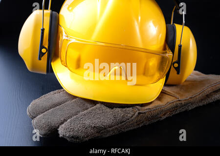 Helmet and accessories for construction workers. Accessories needed for work on the construction site. Dark background. Stock Photo
