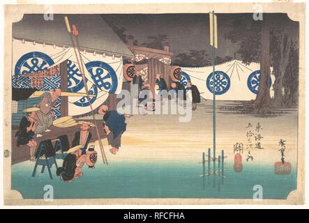 Station Forty-Eight: Seki, Early Departure from the Headquarters Inn, from the Fifty-Three Stations of the Tokaido. Artist: Utagawa Hiroshige (Japanese, Tokyo (Edo) 1797-1858 Tokyo (Edo)). Culture: Japan. Dimensions: 8 7/8 13 5/8 in. (22.5 x 34.6 cm). Date: ca. 1833-34.  At dawn, a daimyo's procession leaves the inn in Seki, a government checkpoint in Ise Province. A palanquin stands ready behind the master of the inn, and a few bearers still have time to enjoy their smokes. White banners, probably with a daimyo's crest, hang around the inn. Among the advertisement labels behind the master of  Stock Photo