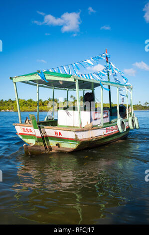 BAHIA, BRAZIL - FEBRUARY, 2016: An old-fashioned wooden Brazilian fishing boat is decorated with blue and white streamers in homage to Yemanja. Stock Photo