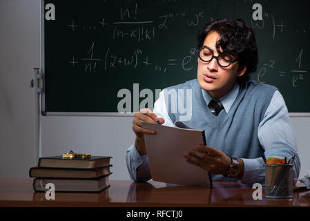 Young math teacher in front of chalkboard Stock Photo