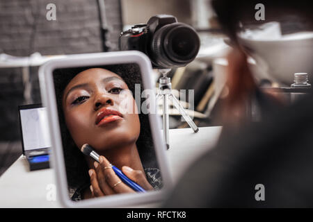 Lovely african american woman with coral lipstick looking busy Stock Photo