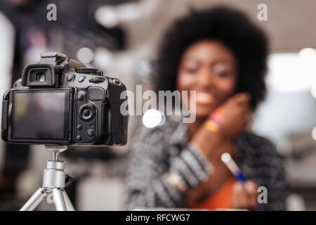 Cute african american woman with curly hair conducting fashion tutorial Stock Photo