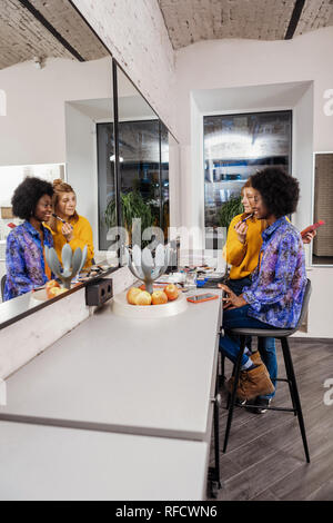 Pretty beaming dark-eyed model feeling good with her stylist Stock Photo