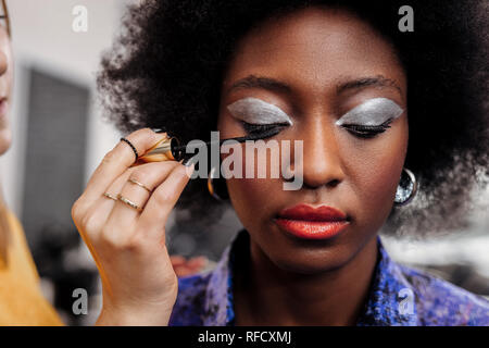 Dark-haired beautiful model with bright lips looking down Stock Photo