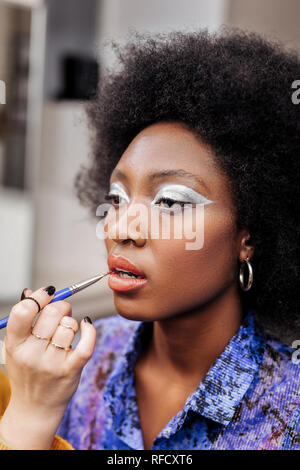 Dark-haired beautiful model with big earrings looking wonderful Stock Photo