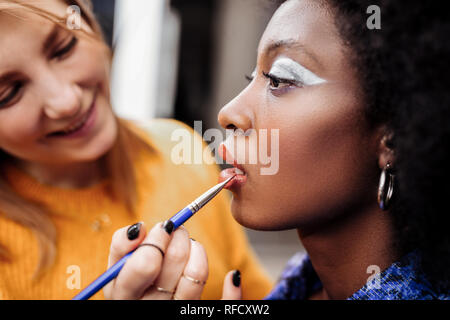 Fair-haired young stylist with black nail polish smiling nicely Stock Photo