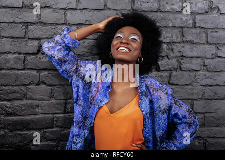 Dark-haired beautiful model with big earrings smiling brightly Stock Photo