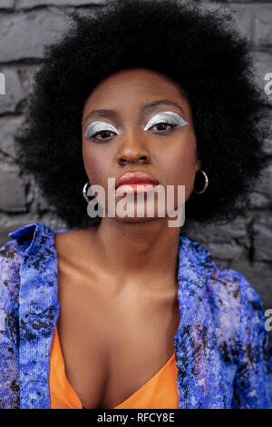 Dark-haired beautiful model with bright makeup looking serious Stock Photo