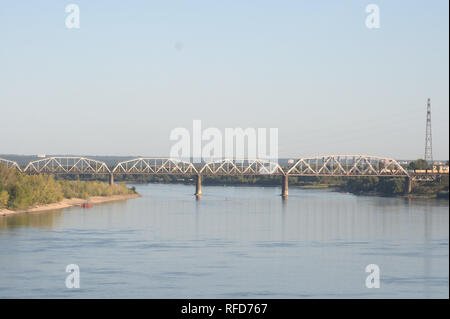 The railway bridge over the river Ob and the edge of the island 'Korablik'. The photo was taken on a summer sunny day from the Bougreen Bridge to the Stock Photo