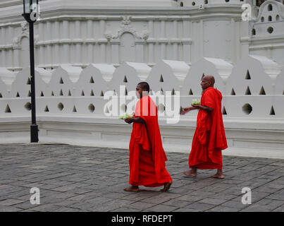 Kandy, Sri Lanka - Dec 15, 2018. Buddhist monks in bright orange robe visit Temple of the Sacred Tooth Relic in Kandy, Sri Lanka. Stock Photo