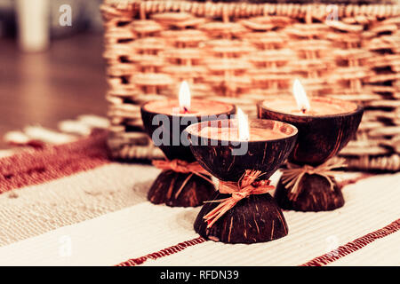 Burning spa aroma candles in coconut shell, cozy home interior Stock Photo