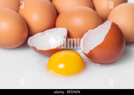 broken and whole chicken eggs on white background Stock Photo