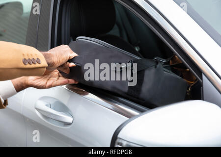 Close-up Of A Man's Hand Stealing Suitcase From Car Stock Photo