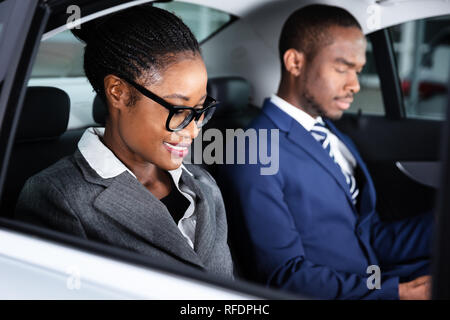 Close-up Of Two Smiling African Businesspeople Traveling By Car Stock Photo