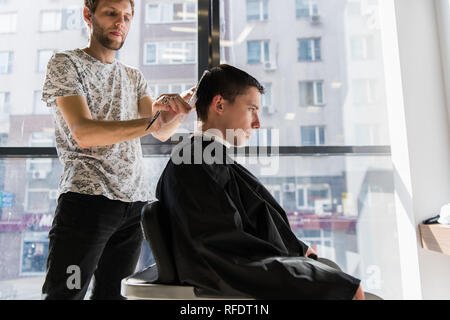 Men's hairstyling and haircutting in a barber shop or hair salon Stock Photo