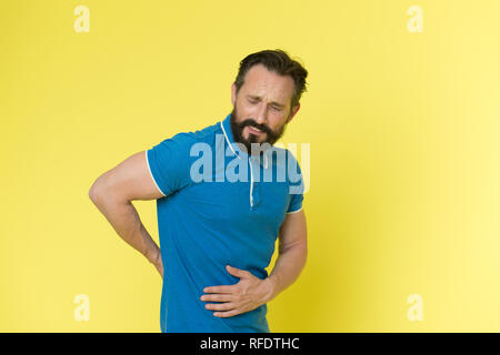Sports injury. Man mature sportsman painful face got injured. Problems with health appears with ageing. Man touch lower back. Guy feels pain in lower back. Healthcare and injuries concept. Stock Photo