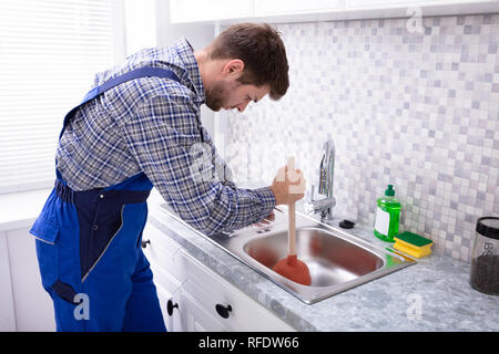 Man Using a Plunger to unstop his bathroom sink 4817267 Stock Photo at  Vecteezy