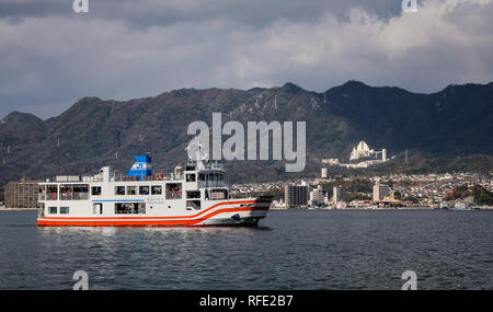 Hiroshima, Japan - Dec 28, 2015. Ferry carrying tourists to Miyajima Island. The Island of Gods, well known for its floating shrine and Otorii. Stock Photo