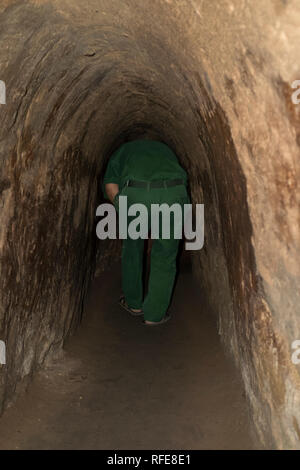 A soldier leads the way in one of the tunnels at Cu Chi. In Saigon, Ho Chi Minh City, Vietnam. Stock Photo