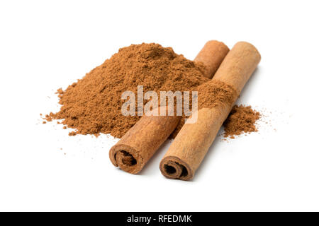Heap of ground cinnamon and cassia cinnamon sticks isolated on white background Stock Photo