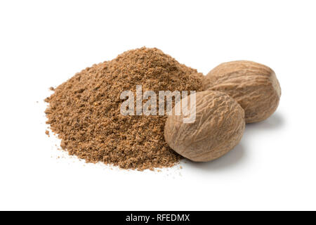 Heap of ground nutmeg and whole nutmeg seeds isolated on white background Stock Photo