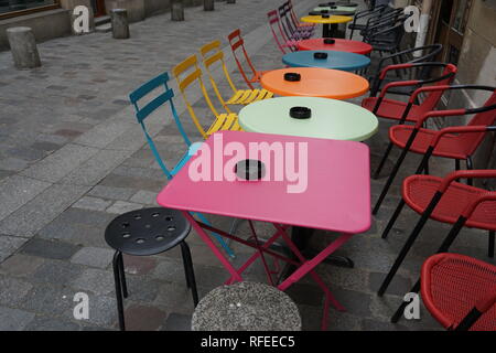 Fun and colorful tables and chairs at an outdoor cafe in France in a pedestrian street Stock Photo