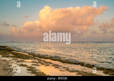 The shoreline reflect clouds at sunset time. San Andrés island, Colombia. Stock Photo