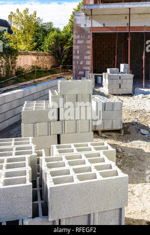 Concrete blocks stacked on pallets outdoors in front of a detached house under construction in the suburbs of Paris, France. Stock Photo