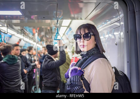 Beautiful woman stands while using Marmaray train in subway metro,Istanbul,Turkey. Stock Photo