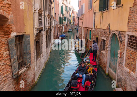 Gondola, the traditional Venetian boat, on canal with tourists, Venice, Italy Stock Photo