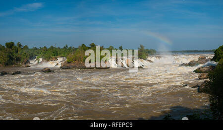 Khone Phapheng Falls is waterfall located in Champasak province on the Mekong river in    southern Laos. Rainbow over waterfall. Stock Photo