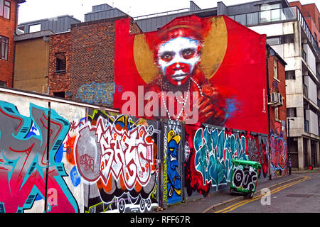Aboriginal face on red background of graffiti, Spear St, Northern Quarter, Manchester, England, UK Stock Photo