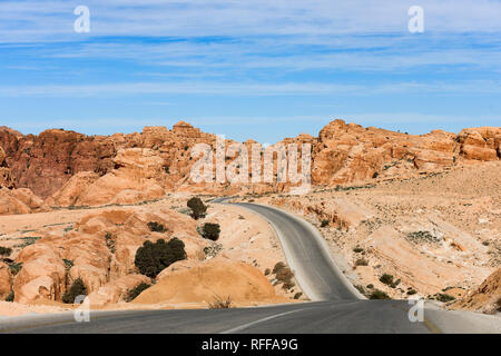 Kings highway, beautiful curvy road running through the Wadi Rum desert with rocky mountains in the distance in Jordan. Stock Photo