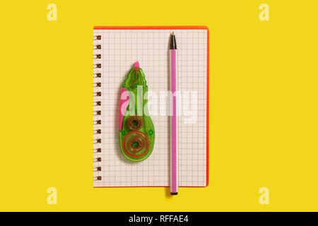 tape corrector and pen lying on a notebook Stock Photo
