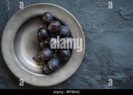 Dark grapes on pewter dish Stock Photo