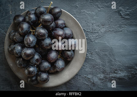 Dark grapes on pewter dish Stock Photo